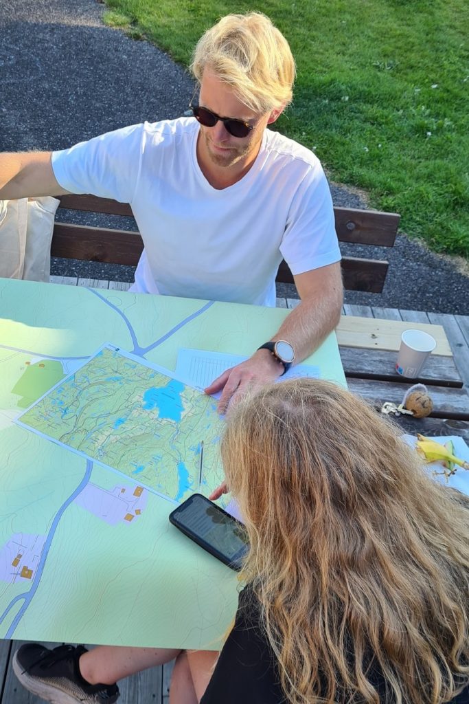 To personer sitter med et kart mellom seg.