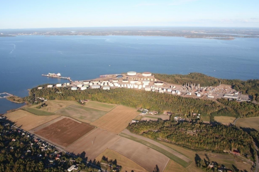 Stort raffineriområde sett ovenifra med fjorden i bakgrunnen. Næringsområdet er omgitt av natur.