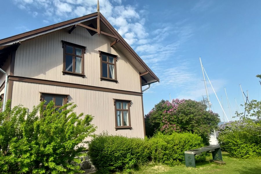 Bestyrerboligen er en toetasjes villa omgitt av en grønn hage.